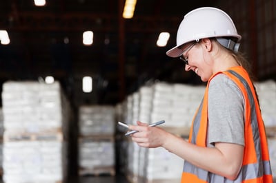 Woman smiling checking list in warehouse