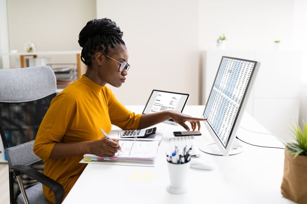 African American woman auditing figures on computer